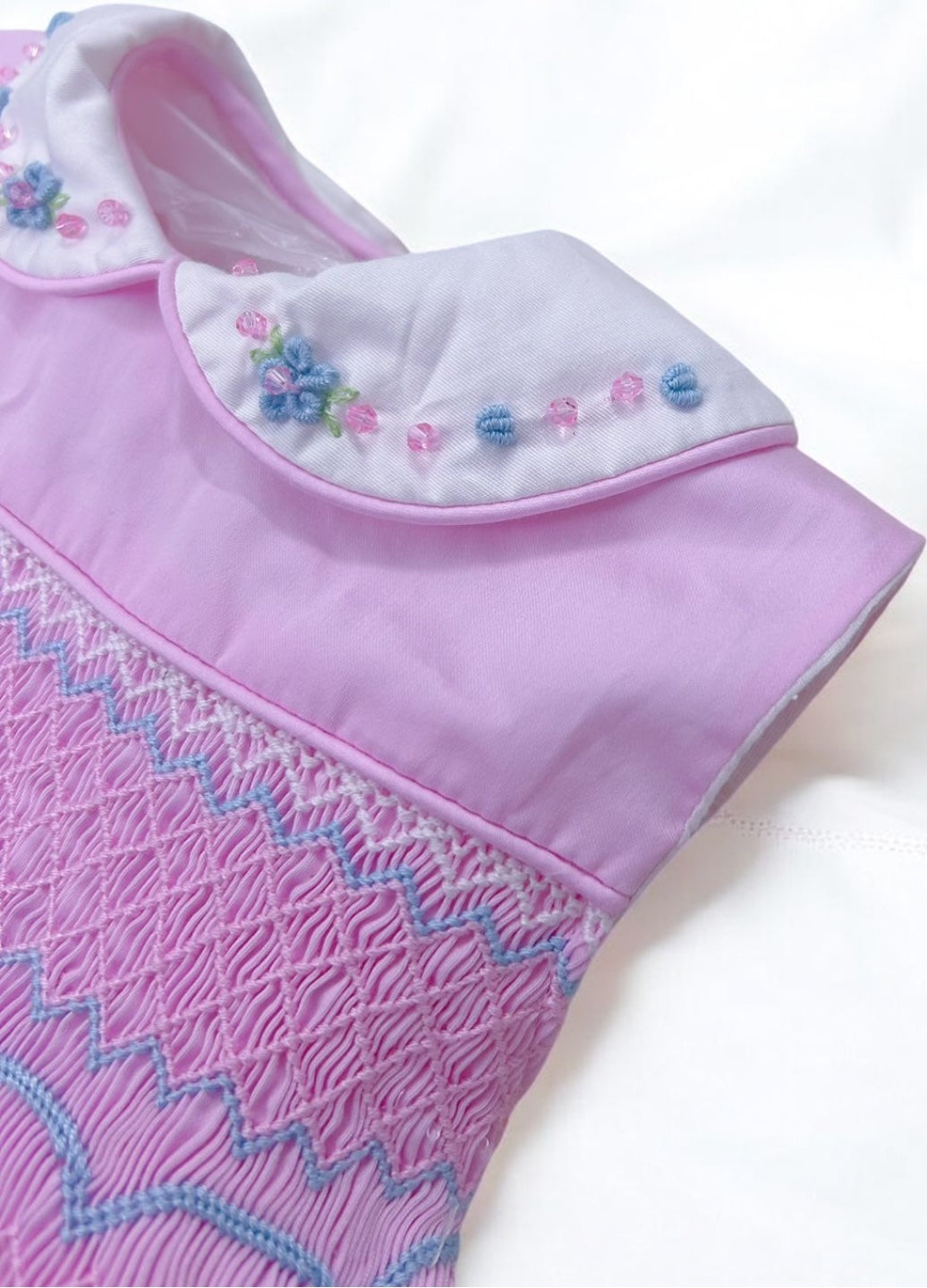 Pink sleeveless with blue embroidery and bead detail on collar