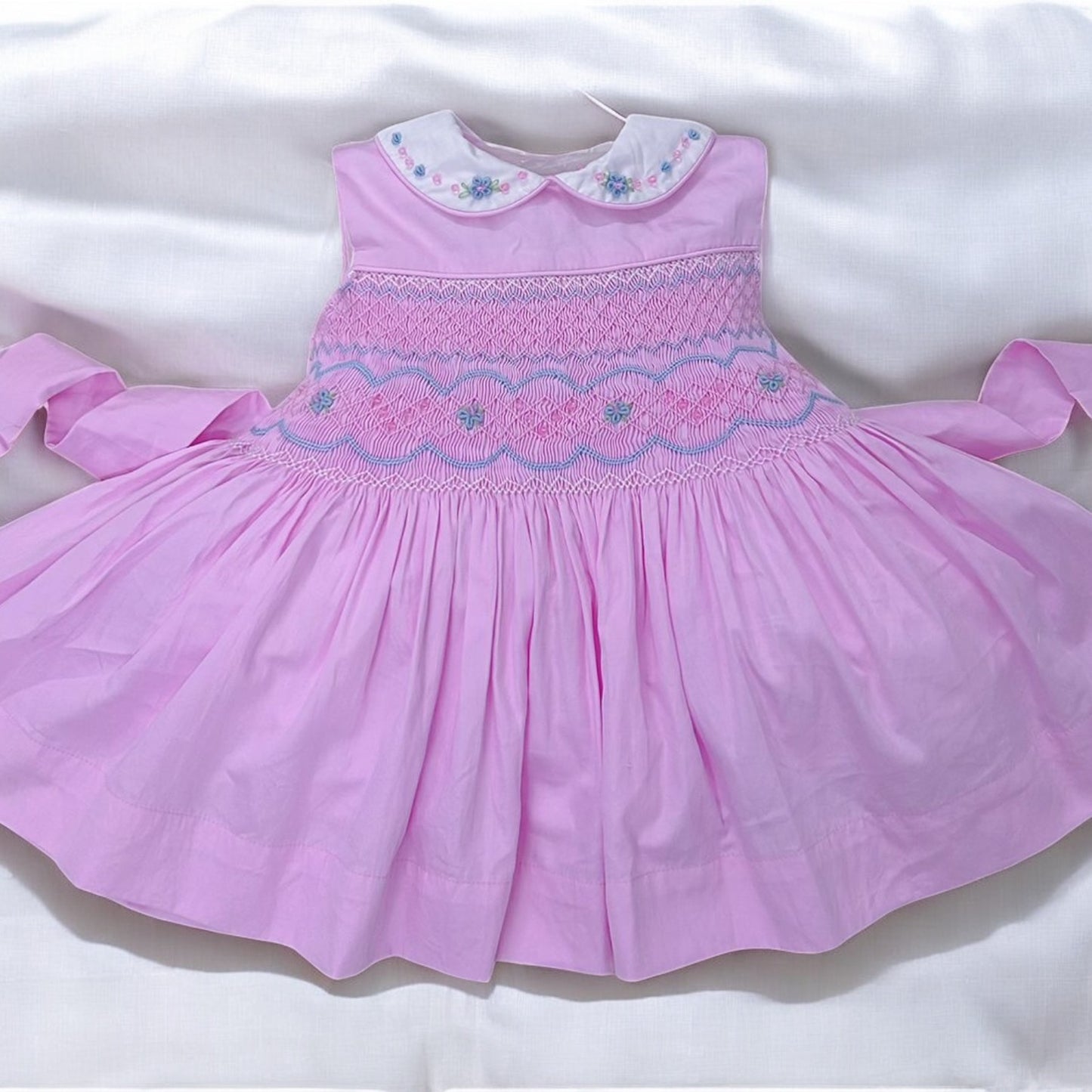 Pink sleeveless with blue embroidery and bead detail on collar