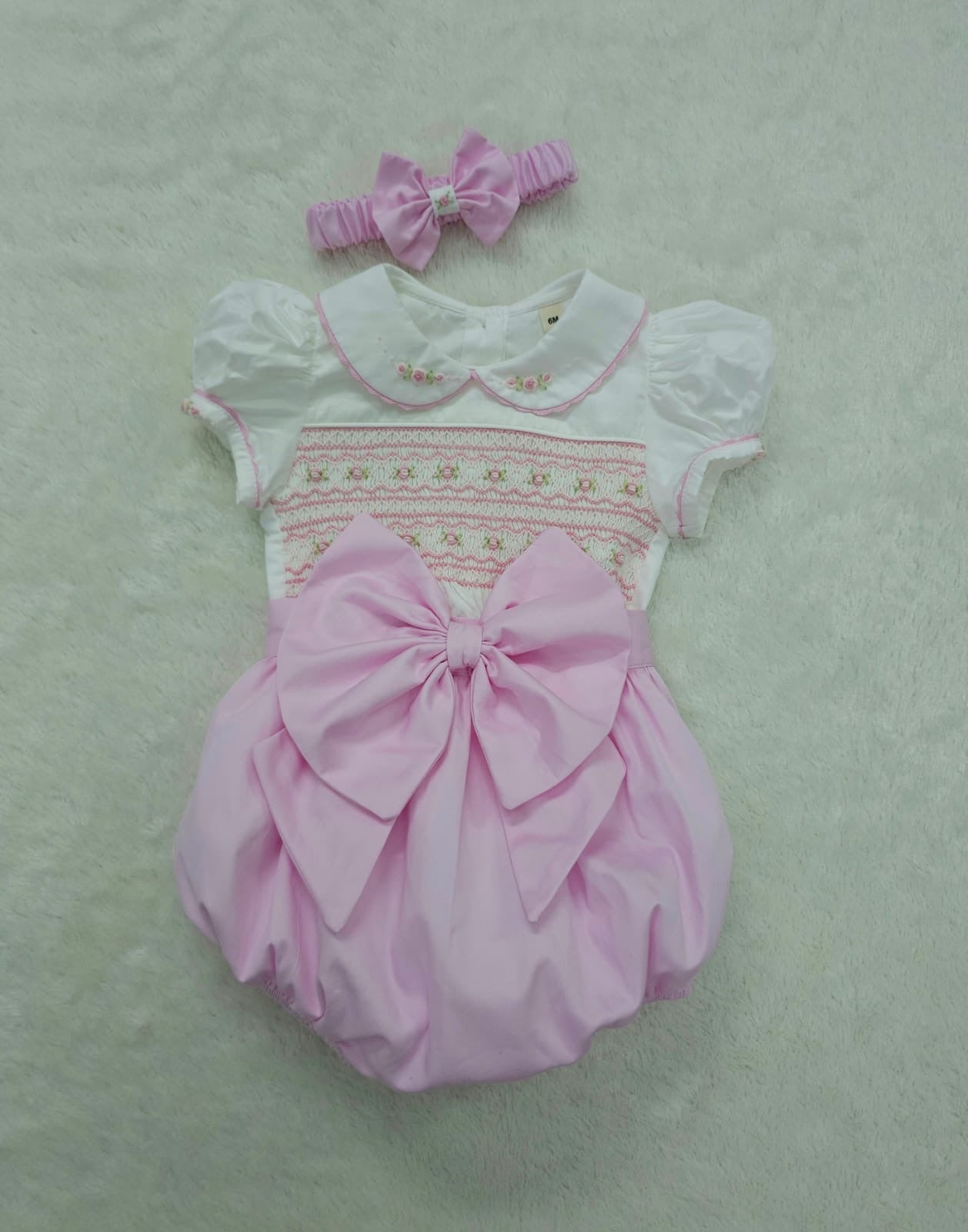 Pink smocked romper comes with matching hair bows or headband for baby sizes