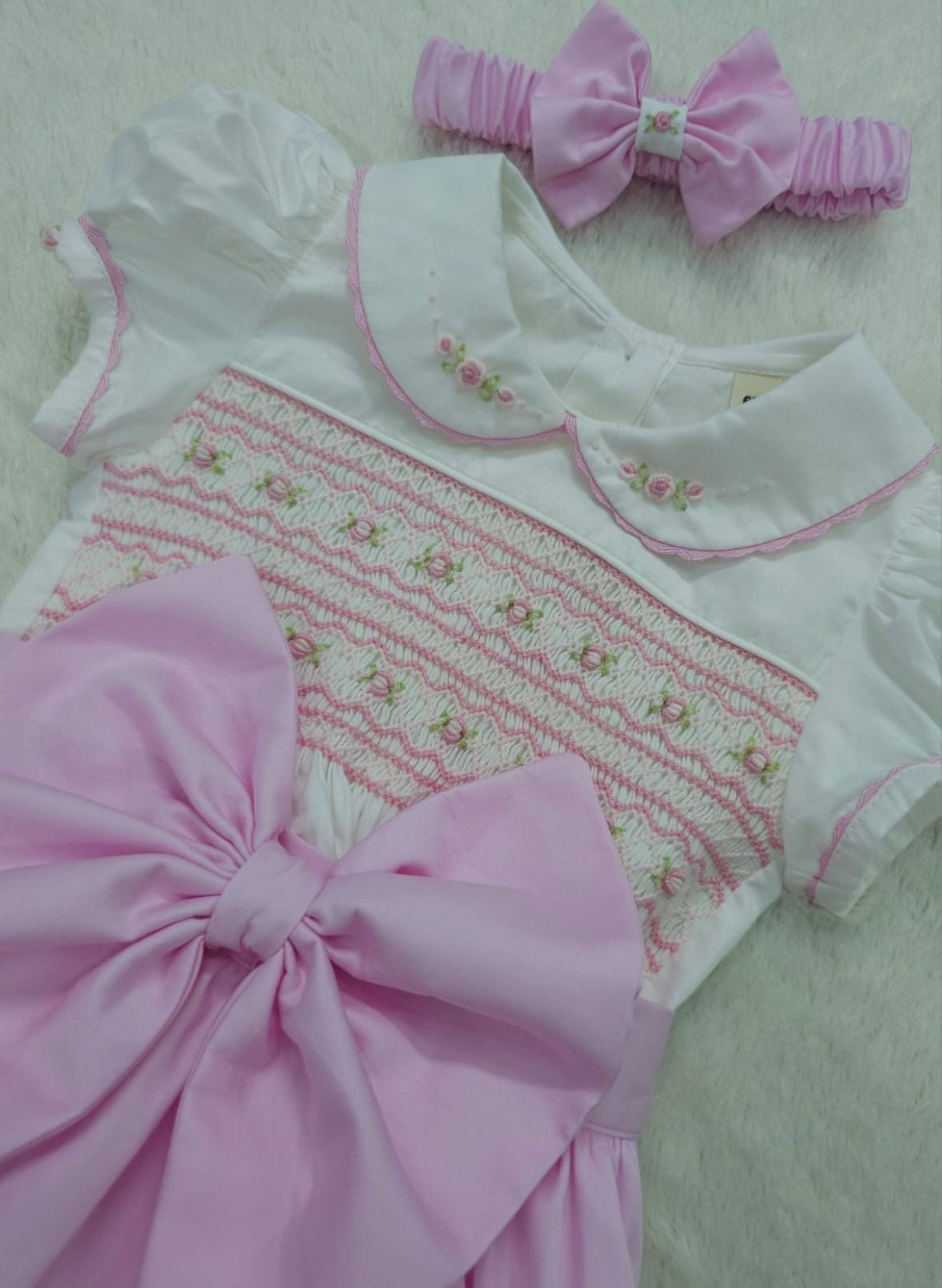 Pink smocked romper comes with matching hair bows or headband for baby sizes