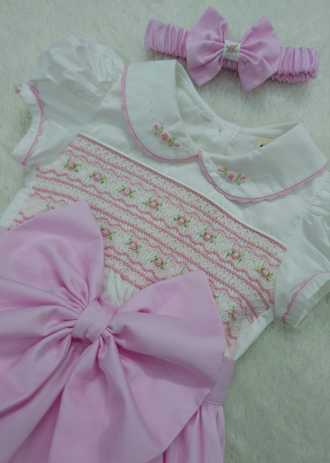 Pink smocked romper comes with matching hair bows or headband for baby sizes