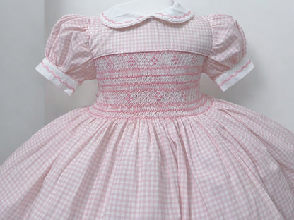 Pink gingham smocked dress. Fitted petticoat and comes with knickers and hair bows