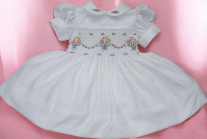 White smocked dress with embroidered flower baskets