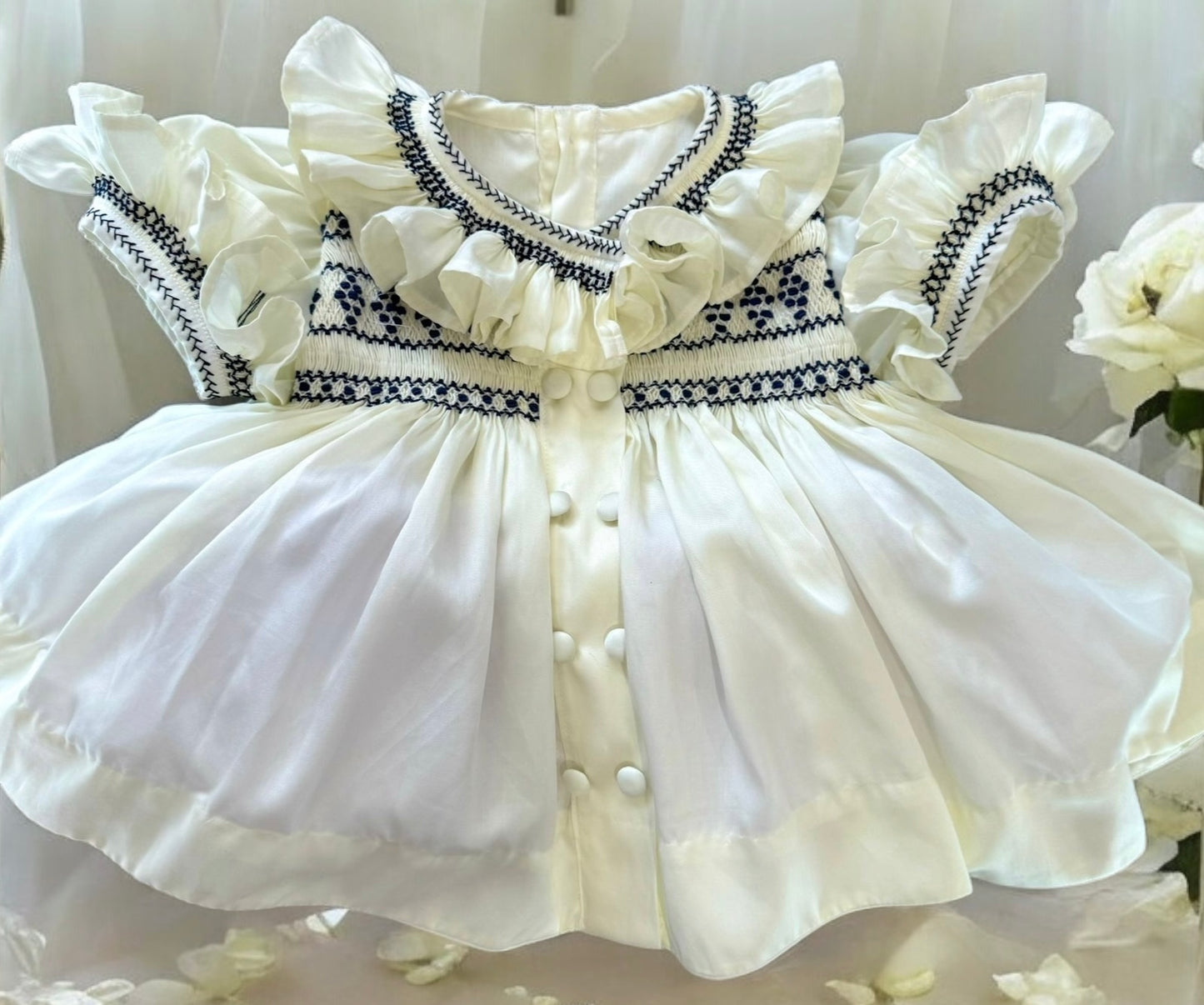 Cream dress with navy smocking on chest sleeve and collar