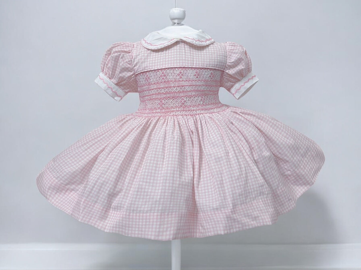 Pink gingham smocked dress. Fitted petticoat and comes with knickers and hair bows