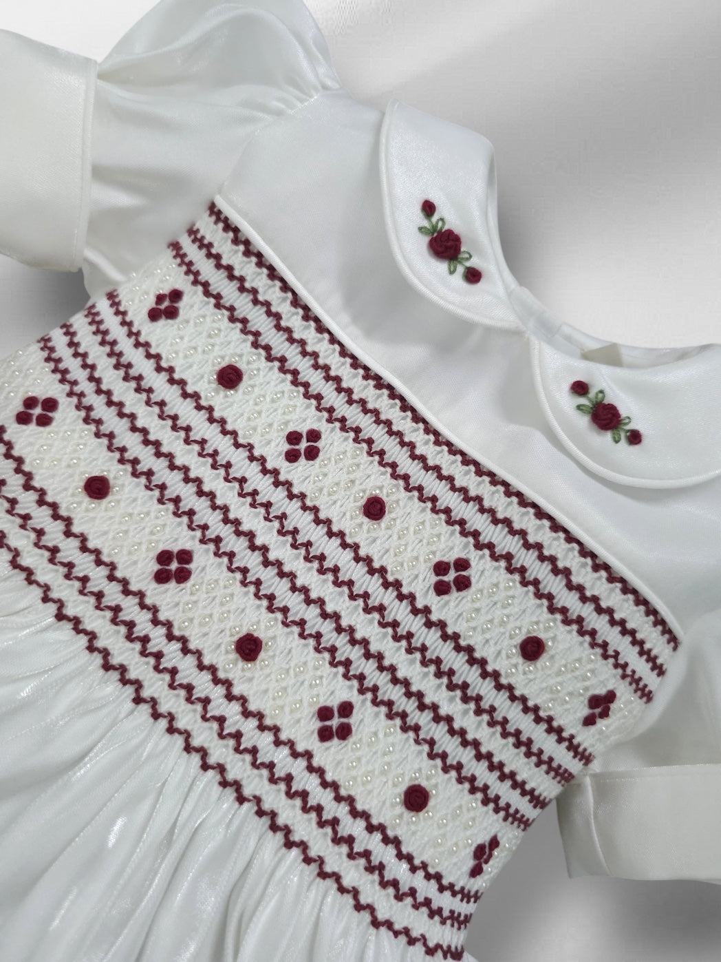 White shimmer with burgandy smocking and pearls